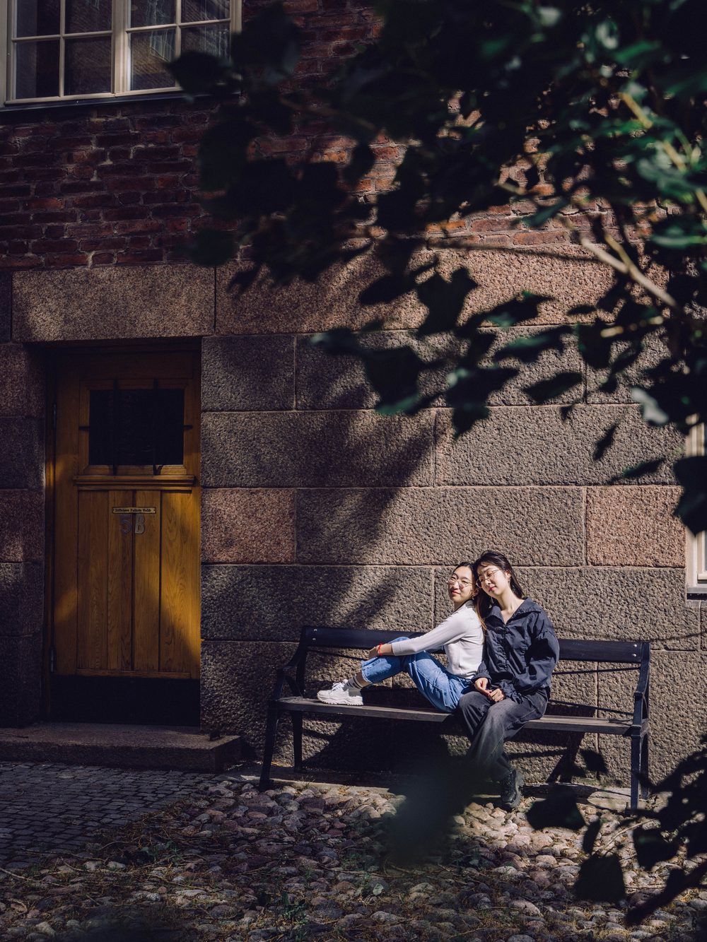Two friends on a bench in dappled afternoon light