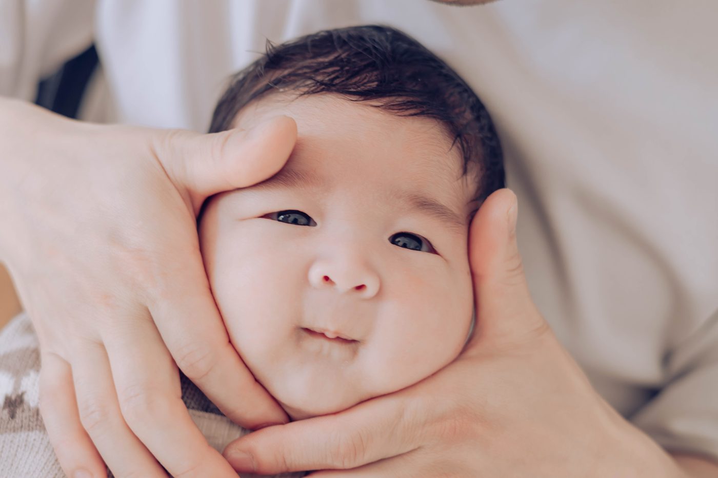 A newborn baby held in gentle hands