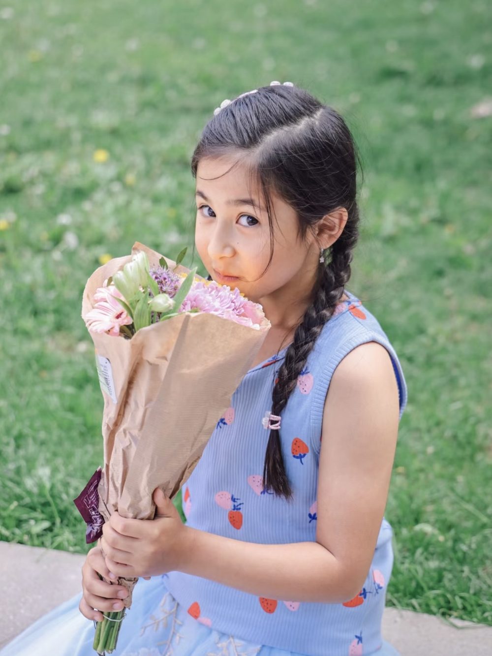 A girl with braids holding a bouquet