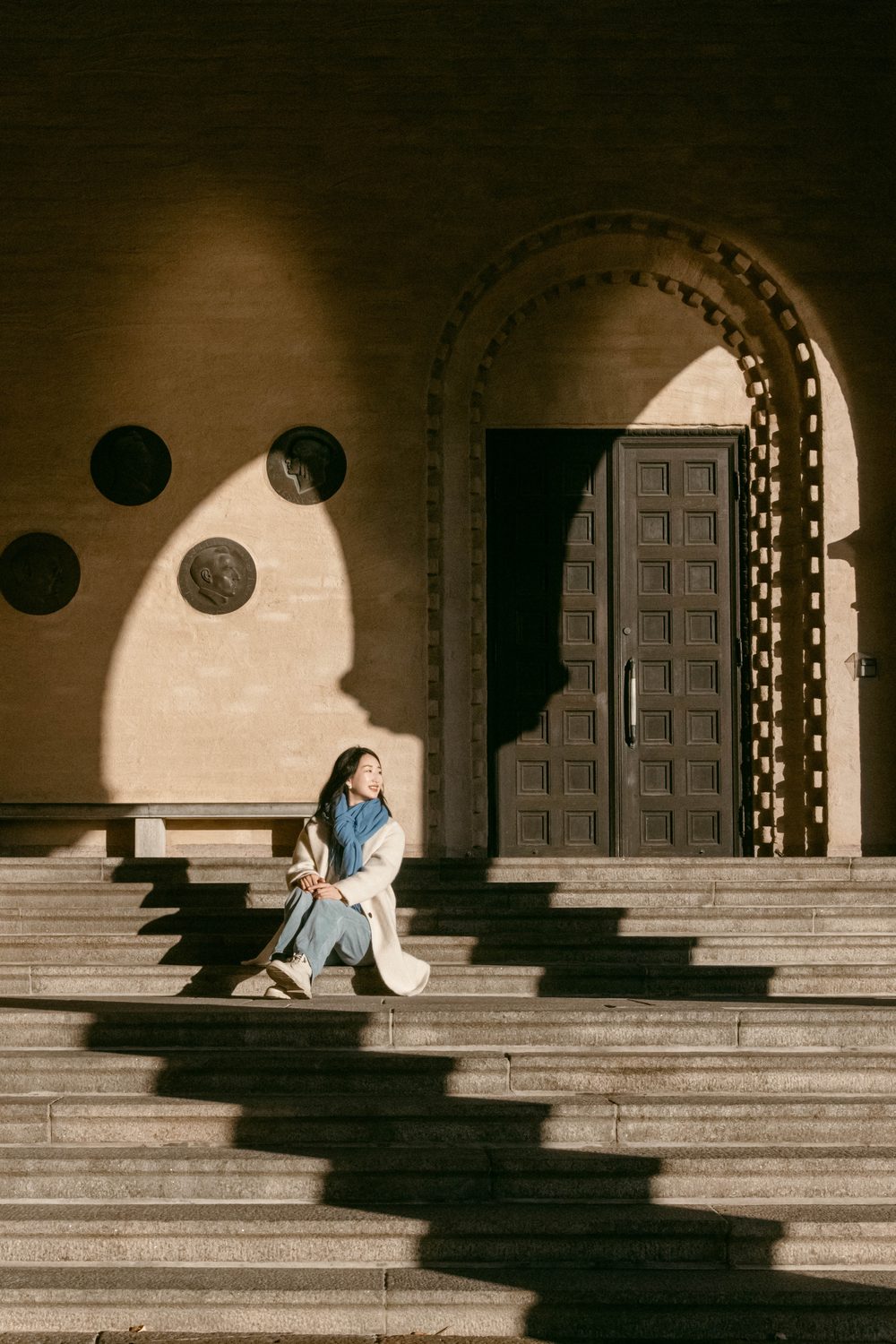 Sitting on a grand staircase in hard light and shadow